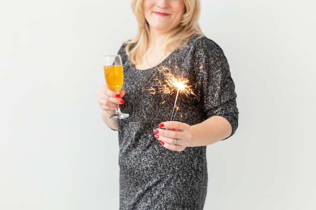 Vakantie, kerst, verjaardag en nieuwjaar concept - vrouw viert en houdt wijn in een glas en een sterretje op een witte achtergrond, close-up