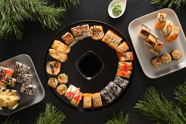 Vakantie kerstbrunch van sushi ingesteld als krans op zwarte achtergrond.