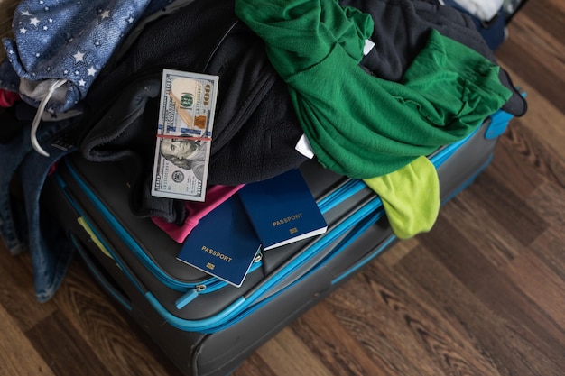 Vakantie koffer. verspreide kleding, paspoort, geld