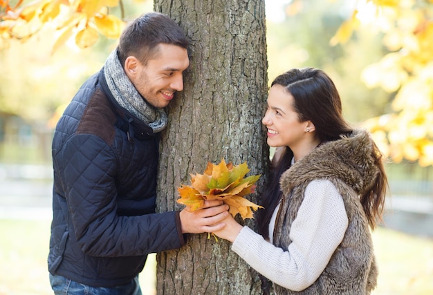 vakantie, liefde, reizen, toerisme, relatie en datingconcept - romantisch koppel dat in het herfstpark speelt