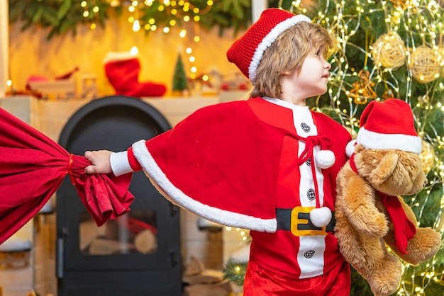 Foto vakantie met het gezin. jongenskind spelen in de buurt van kerstboom.