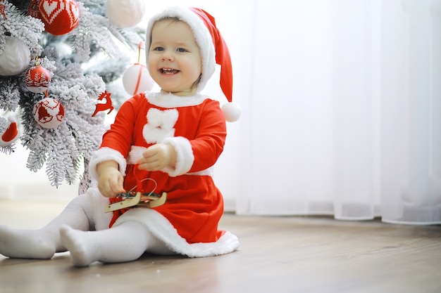 Vakantie met het gezin Meisje schattig kind vrolijk humeur spelen in de buurt van kerstboom