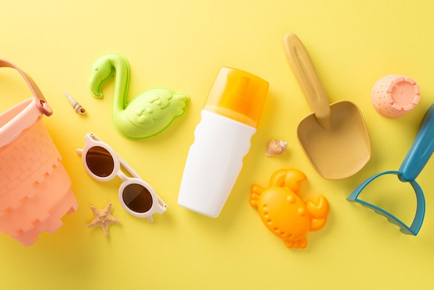 Vakantie met kinderen concept Bovenfoto van zonnebrandcrème spray strand speelgoed voor zandfiguren en zandkasteel en zonnebril op gele geïsoleerde achtergrond