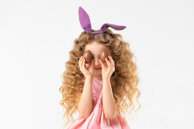 Foto vakantie pasen kinderen meisje met konijn haas konijnenoren mand met chocolade-eieren