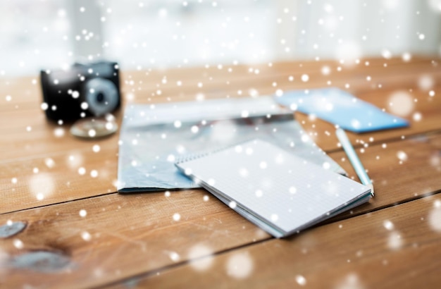 vakantie, toerisme, reizen, wintervakanties en objecten concept - close-up van een leeg notitieboek met kaart en vliegtickets