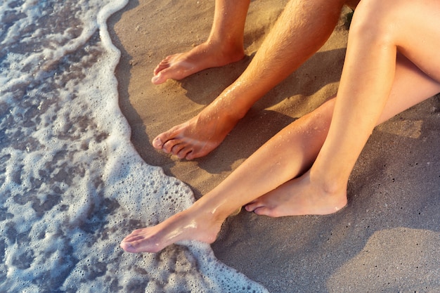 Vakantie vakanties. Sluit omhoog van mannelijke en vrouwelijke voeten op het strand.