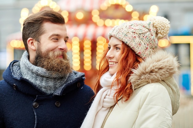Vakantie, winter, kerst en mensen concept - gelukkig paar in warme kleren wandelen in de oude stad