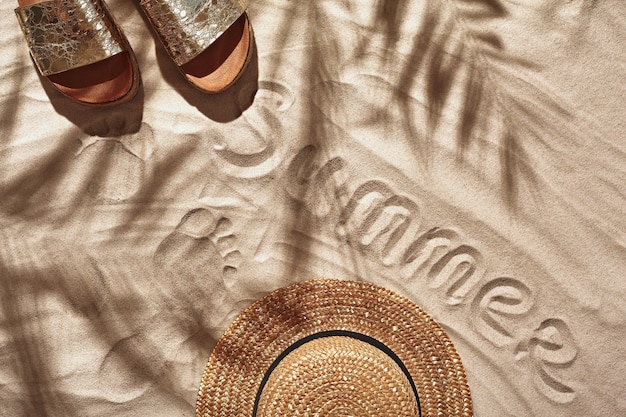 Vakantieaccessoires voor reizigers zijn neergelegd op een wit strandzand, platliggend bovenaanzicht