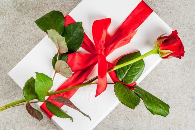 Vakantieachtergrond, valentijnsdag. verpakte geschenkdoos met een rode roos bovenaanzicht