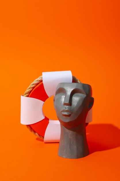 Foto vakantieconcept met decoratief hoofd op oranje achtergrond