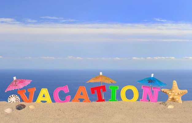 Vakantieletters op een strandzand tegen de achtergrond van de zee