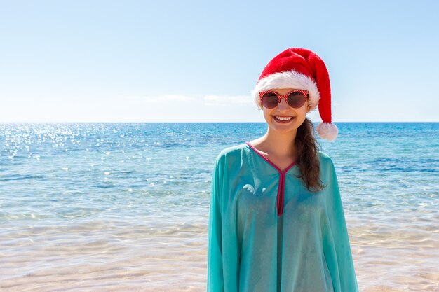 Vakantievrouw in santahoed het ontspannen op paradijsstrand, kerstmisvakantie