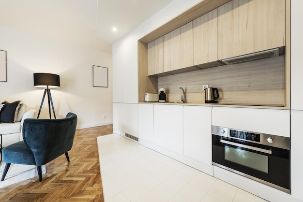 Vakantiewoning in loftstijl met een open keuken naar de woonkamer met witte kasten gecombineerd met eikenhouten oppervlakken en eiken parketvloeren