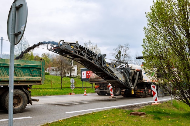 Valasske mezirici, tsjechië, 23 april 2019: wegenreparatie. freesmachine haalt oud asfalt van de weg