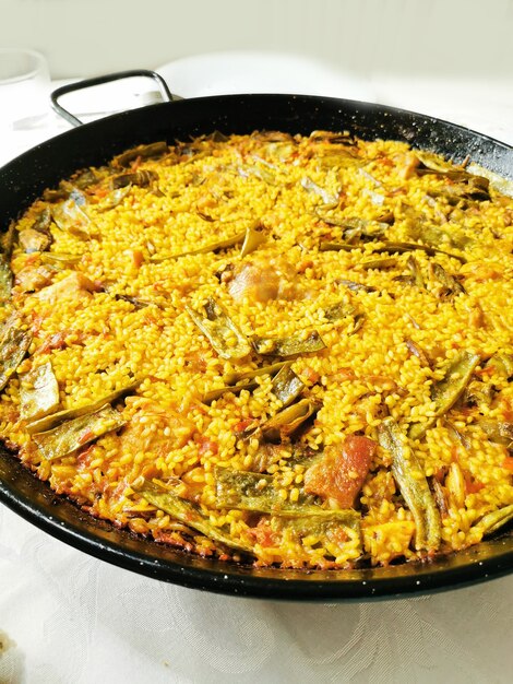 Valencian paella cooking on log fire in local Spainish village