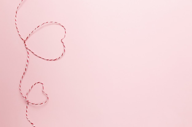 Valentijn kaart. Hartvormen van rood wit koord of touw. Roze achtergrond. Hoge kwaliteit foto
