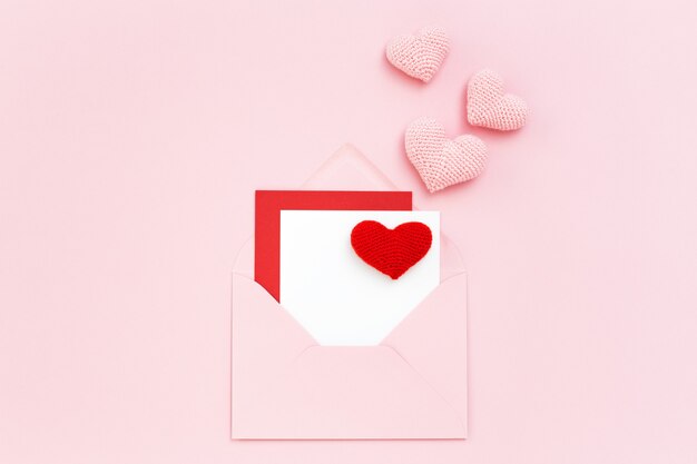 Valentijn kaart in roze envelop met rode en roze harten. Kopieer de ruimte, plat leggen.