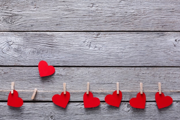 Foto valentijn met rode papieren hartjes op wasknijpers grens op rustieke houten planken