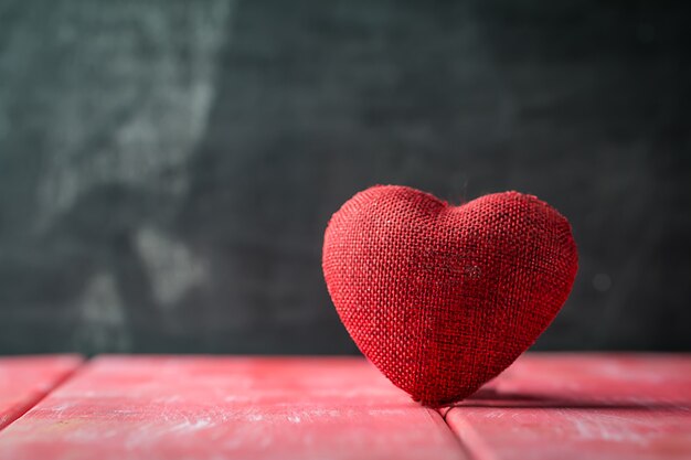 Valentijnsdag achtergrond met rood hart over rode houten tafel