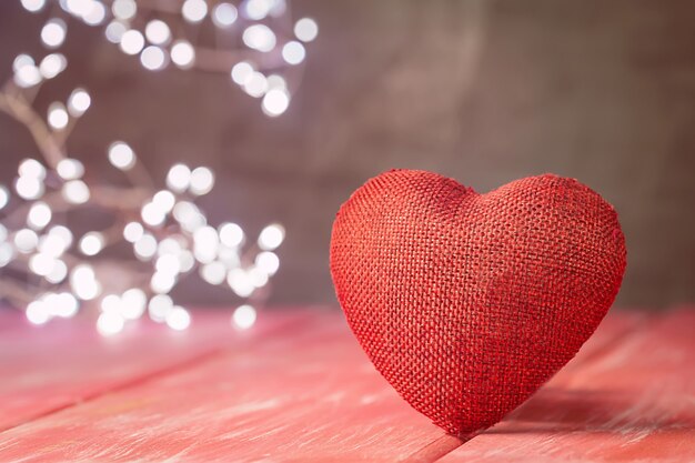 Valentijnsdag achtergrond met rood hart over rode houten tafel
