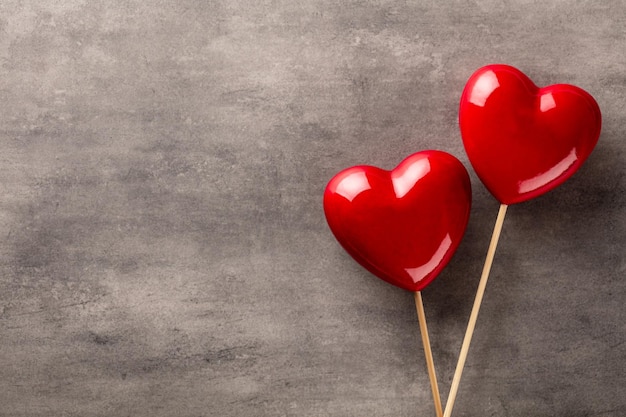 Valentijnsdag achtergrond met twee rode harten op pastel achtergrond