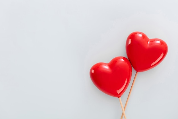 Foto valentijnsdag achtergrond met twee rode harten op pastel achtergrond