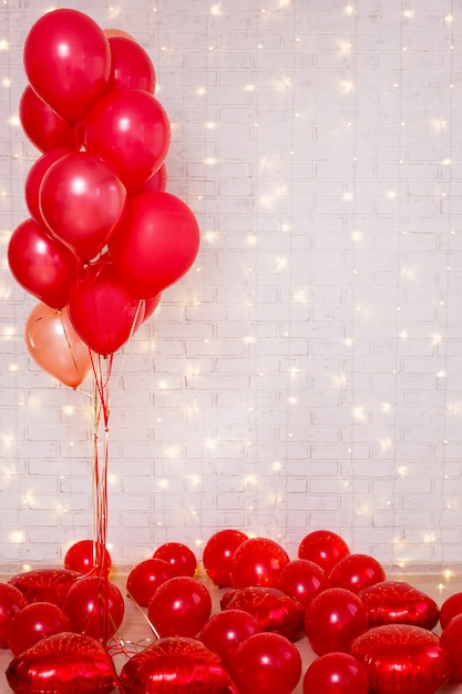 Valentijnsdag achtergrond - rode ballonnen over witte bakstenen muur met kopie ruimte