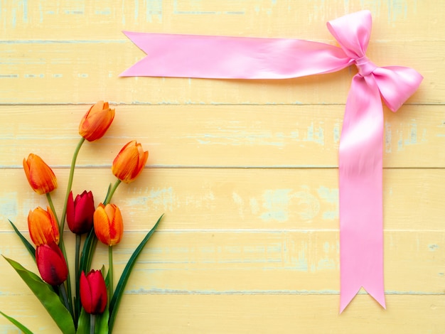 Valentijnsdag achtergrond. Roze lint en bloem op houten achtergrond.