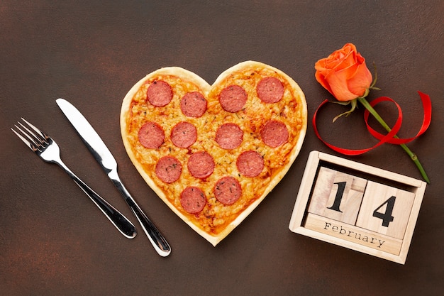 Foto valentijnsdag arrangement met hartvormige pizza