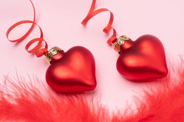 Valentijnsdag banner bestaande uit rode glazen harten met pluizige roze veren met kopie ruimte voor de tekst