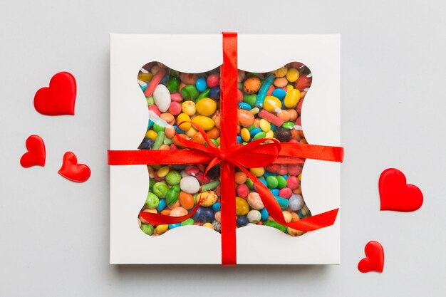 Foto valentijnsdag compositie zoete snoep met geschenk dozen met boog en rode gevoelde harten foto sjabloon achtergrond top view met kopieerruimte