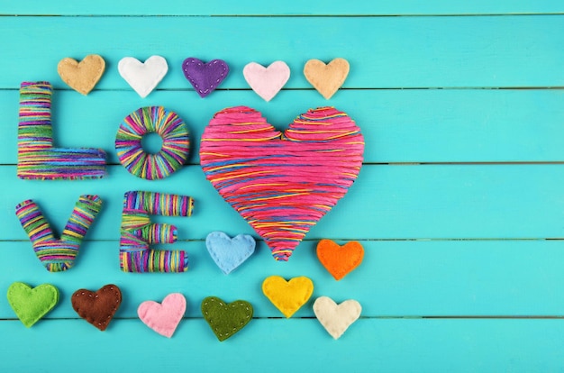 Valentijnsdag concept Samenstelling van kleurrijke handgemaakte harten op turquoise houten achtergrond