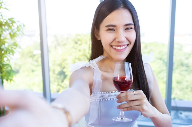 Valentijnsdag concept, Selfie van Happy van lachende Aziatische jonge vrouw zittend aan een tafel eten houden met wijnglazen op in de achtergrond van het restaurant