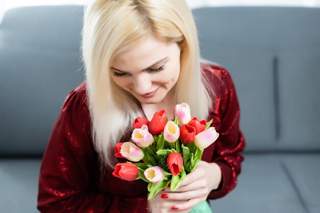 Valentijnsdag, dromende jonge vrouw met een boeket bloemen.