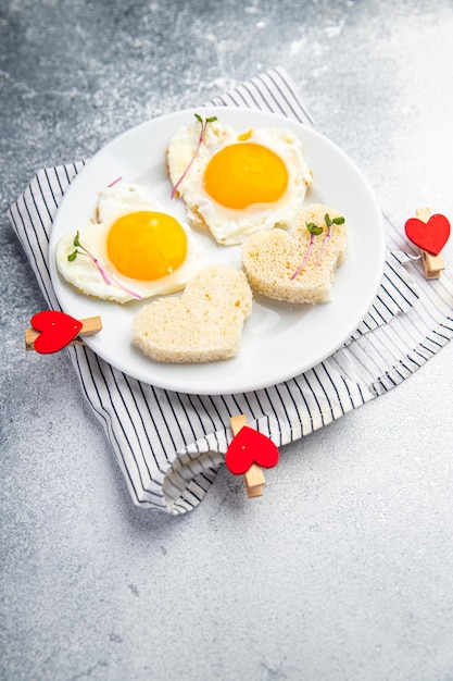 Valentijnsdag ei gebakken ontbijt op tafel roerei hartvorm vakantie decoratie liefde