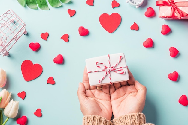 Valentijnsdag en verjaardag Vrouwenhanden met geschenk of huidige doos versierd en rood hartverrassing