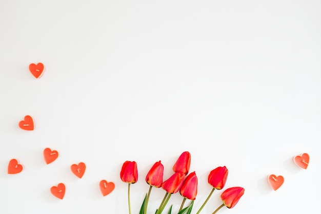 Valentijnsdag frame gemaakt van een boeket rode tulpen harten op een witte achtergrond met een kopie ruimte