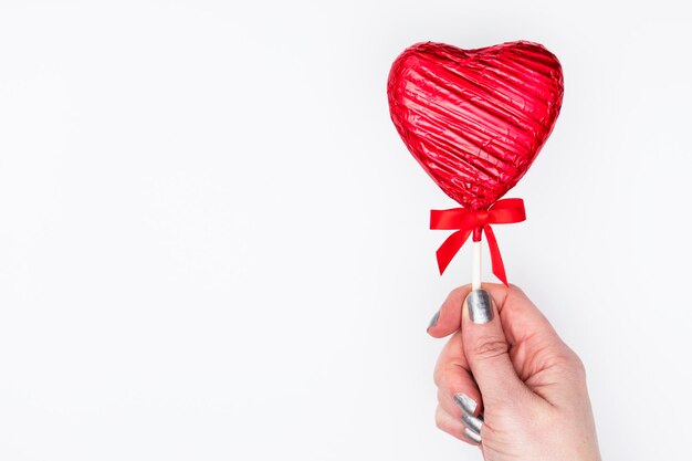 Valentijnsdag geschenk Vrouwelijke hand met een hartvormige lolly