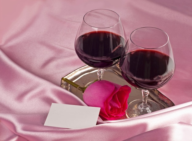 Valentijnsdag. geschenkdoos, bloemen, glazen met wijn op de roze kleur achtergrond