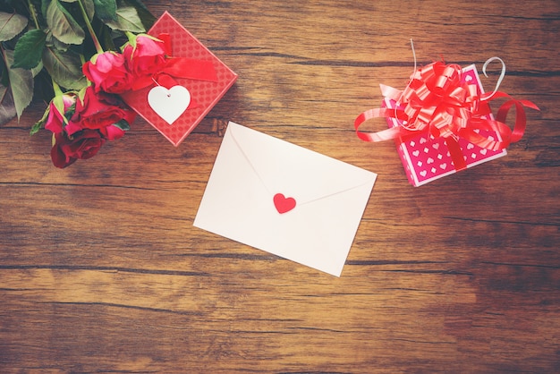 Valentijnsdag geschenkdoos rood en roze op hout Valentijnsdag kaart rood roze bloem en geschenkdoos