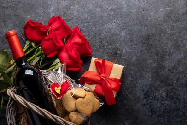 Valentijnsdag kaart met wijnfles koekjes en roze bloemen