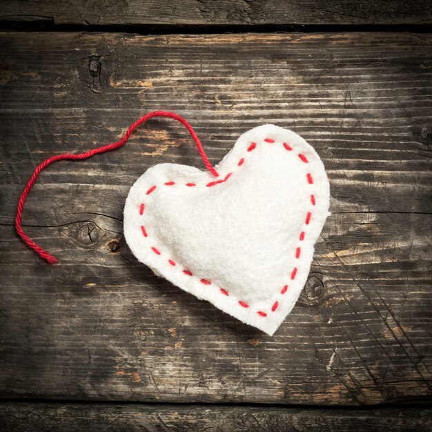 Foto valentijnsdag. kleurrijke gebreide harten. rood hart op de donkere oude planken.