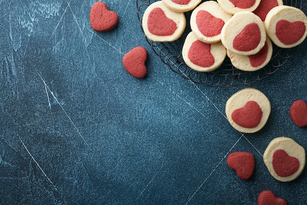 Valentijnsdag koekjes Zandkoekkoekjes in een zoet rood hart op perkamentpapier op donkerblauwe achtergrond Moederdag Vrouwendag Zoete feestdagen bakken Bovenaanzicht