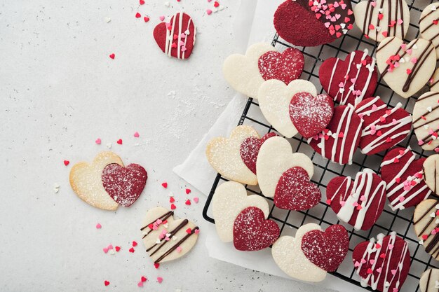 Valentijnsdag koekjes Zandkoekkoekjes in zoet rood hart met chocoladeglazuur op roze plaat op grijze achtergrond Moederdag Damesdag Zoete feestdagen bakken Valentijnsdagkaart Bovenaanzicht