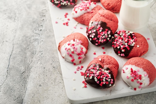 Valentijnsdag koekjes Zandkoekkoekjes met glazuur witte en pure chocolade en hagelslag op bord op witte achtergrond Moederdag Damesdag Zoete feestdagen bakken Bovenaanzicht