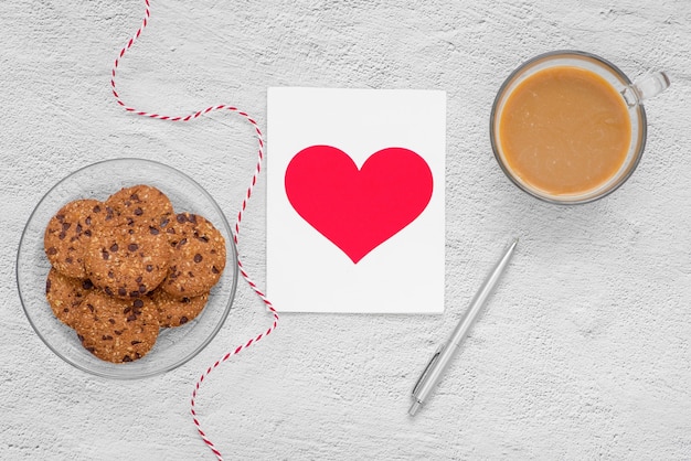 Valentijnsdag. Kopje koffie en koekjes op een bord op tafel, bovenaanzicht