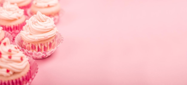 Foto valentijnsdag liefde cupcakes versierd met room en harten op roze achtergrond met kopie ruimte voor tekst