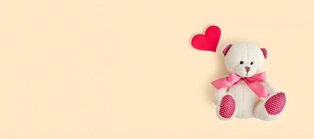 Valentijnsdag liefde hart teddybeer en rood hart op neutrale beige kleur pastel achtergrond vintage retro romantische stijl ongebruikelijke creatieve wenskaart familie bruiloft en vriendschap bovenaanzicht