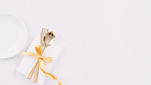 Valentijnsdag Moederdag vakantie dating maaltijd banket ontwerpconcept Witte plaat en gouden lint op marmeren achtergrond bovenaanzicht plat lag