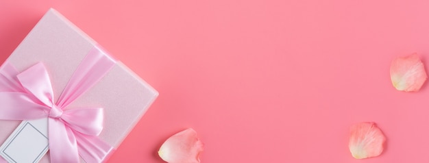 Valentijnsdag ontwerp concept achtergrond met roze bloem en geschenkdoos op roze achtergrond